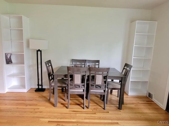 706 Dawes Ave, Utica, NY 13502 - dining area featuring light wood-type flooring, built in shelves, and baseboards
