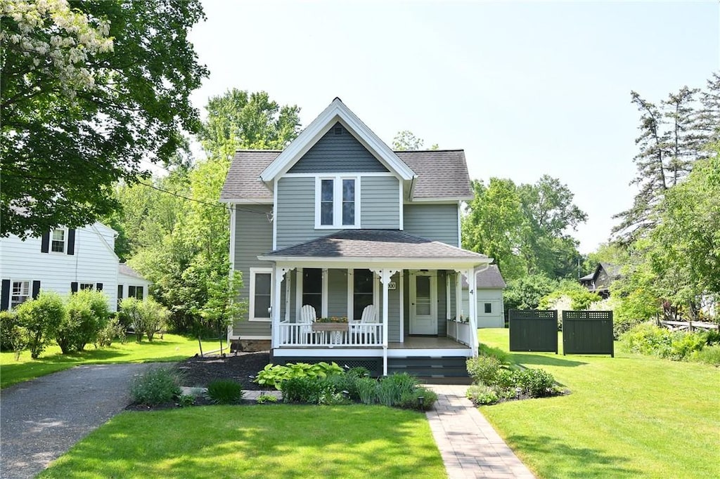 4 Groveland Rd, Geneseo, NY 14454 - view of front of house featuring a porch, a front lawn, and a shingled roof
