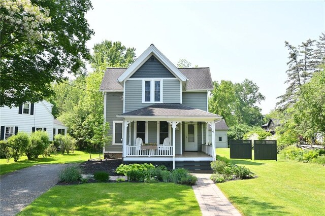 4 Groveland Rd, Geneseo, NY 14454 - view of front of house featuring a porch, a front lawn, and a shingled roof