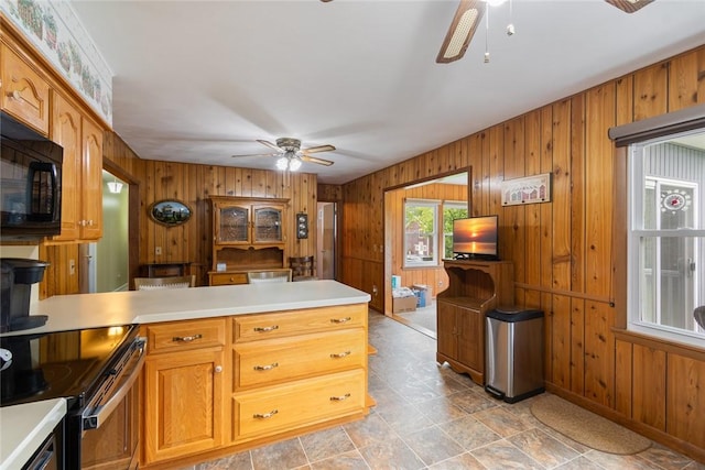 141 W Pearl St, Arcadia, NY 14513 - kitchen featuring a ceiling fan, black microwave, wood walls, light countertops, and a peninsula