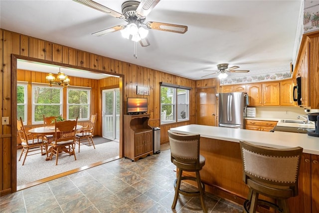 141 W Pearl St, Arcadia, NY 14513 - kitchen with freestanding refrigerator, ceiling fan, wood walls, light countertops, and black microwave