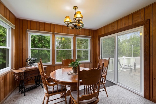 141 W Pearl St, Arcadia, NY 14513 - dining area featuring light carpet, wood walls, and a chandelier