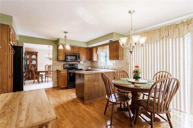 281 Burley Rd, Rochester, NY 14612 - kitchen with electric stove, stainless steel microwave, a chandelier, freestanding refrigerator, and brown cabinetry