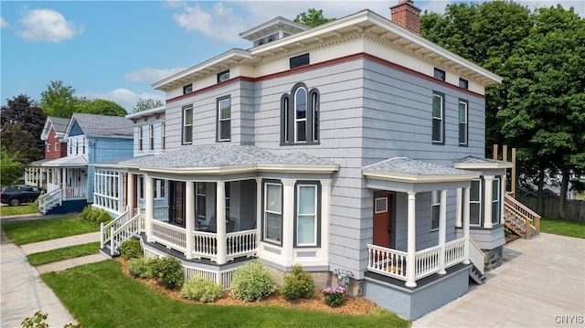 55 E 5th St, Oswego-City, NY 13126 - view of front of property with covered porch, a shingled roof, a chimney, and concrete driveway