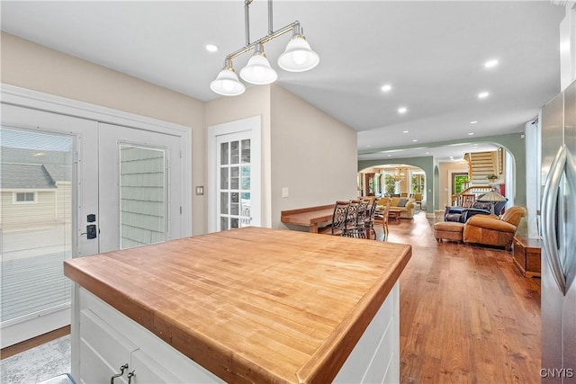 55 E 5th St, Oswego-City, NY 13126 - kitchen with arched walkways, recessed lighting, wood finished floors, white cabinets, and pendant lighting