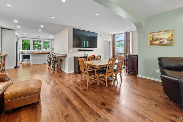 55 E 5th St, Oswego-City, NY 13126 - dining space with healthy amount of natural light, hardwood / wood-style flooring, recessed lighting, baseboards, and arched walkways