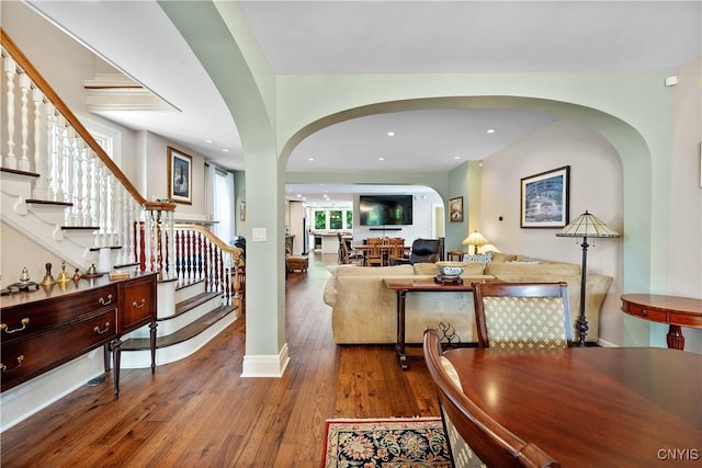 55 E 5th St, Oswego-City, NY 13126 - dining room featuring arched walkways, hardwood / wood-style floors, stairway, recessed lighting, and baseboards