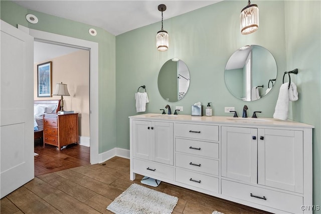55 E 5th St, Oswego-City, NY 13126 - full bathroom with double vanity, wood finished floors, and baseboards