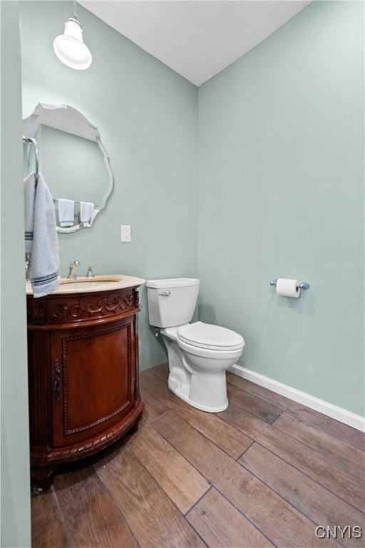 55 E 5th St, Oswego-City, NY 13126 - bathroom featuring hardwood / wood-style flooring, vanity, toilet, and baseboards