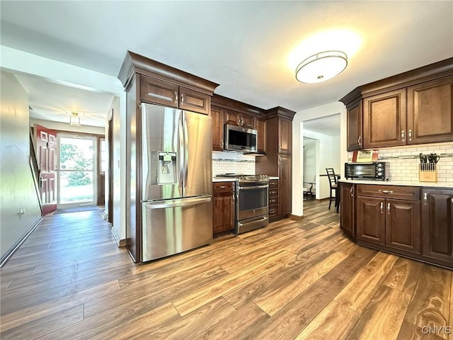4936 Look Kinney Cir, Clay, NY 13088 - kitchen featuring appliances with stainless steel finishes, light wood-style flooring, backsplash, and light countertops