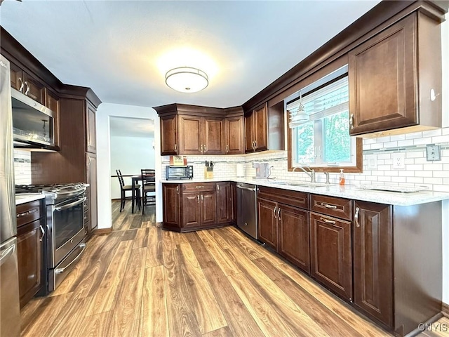 4936 Look Kinney Cir, Clay, NY 13088 - kitchen with stainless steel appliances, a sink, light wood finished floors, tasteful backsplash, and dark brown cabinets