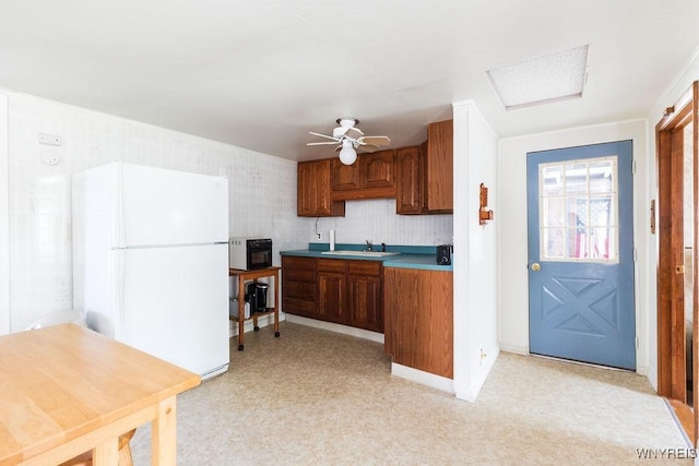 17 Porter Center Rd Unit N, Porter, NY 14174 - kitchen with freestanding refrigerator, a sink, brown cabinets, a ceiling fan, and light countertops