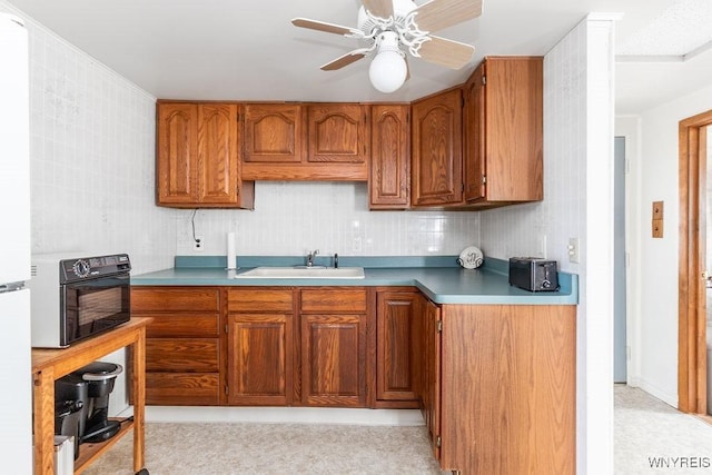 17 Porter Center Rd Unit N, Porter, NY 14174 - kitchen featuring a sink, brown cabinets, a ceiling fan, decorative backsplash, and freestanding refrigerator