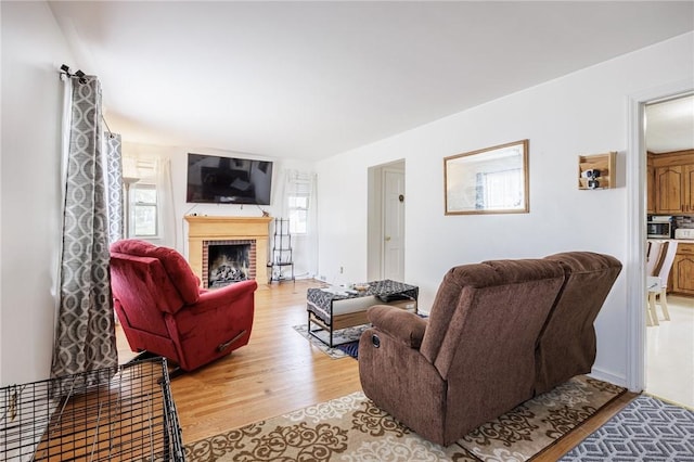 12 Queensboro Rd, Irondequoit, NY 14609 - living area with light wood-style floors, plenty of natural light, and a brick fireplace