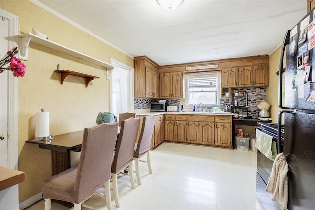 12 Queensboro Rd, Irondequoit, NY 14609 - kitchen featuring range, brown cabinetry, ornamental molding, and freestanding refrigerator