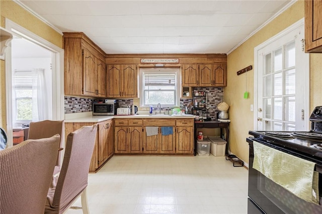 12 Queensboro Rd, Irondequoit, NY 14609 - kitchen featuring black range with electric stovetop, stainless steel microwave, a sink, brown cabinets, and light floors