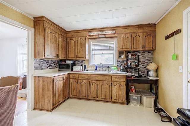 12 Queensboro Rd, Irondequoit, NY 14609 - kitchen featuring a sink, brown cabinetry, light flooring, light countertops, and tasteful backsplash
