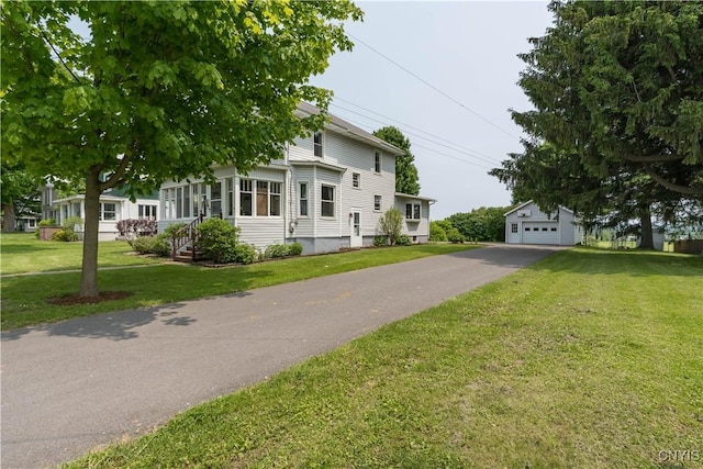 7632 E State St, Lowville, NY 13367 - view of front of house with an outbuilding, a front lawn, and a detached garage