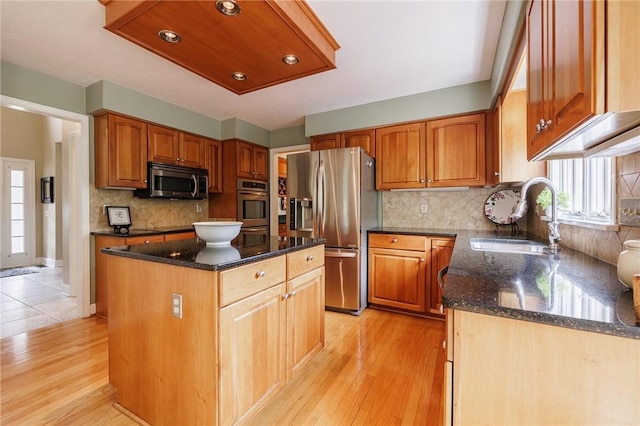 74 Broadmoor Trl, Perinton, NY 14450 - kitchen with stainless steel appliances, a sink, dark stone counters, a kitchen island, and light wood-style floors