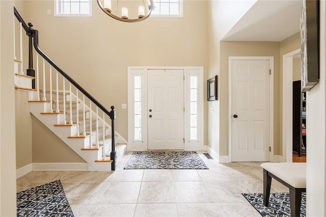 74 Broadmoor Trl, Perinton, NY 14450 - tiled foyer entrance with a high ceiling, a chandelier, stairway, and baseboards