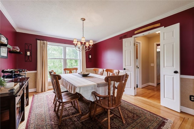 74 Broadmoor Trl, Perinton, NY 14450 - dining room with a chandelier, light wood-style floors, ornamental molding, baseboards, and a textured ceiling