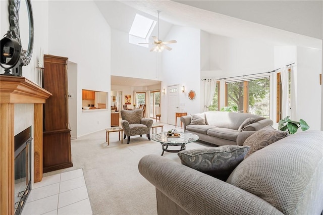 3 Legacy Oak Trl, Henrietta, NY 14534 - living area featuring high vaulted ceiling, light carpet, a skylight, a ceiling fan, and a fireplace with flush hearth