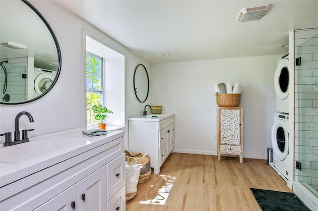 2309 Mcburney Rd, Phelps, NY 14432 - washroom featuring stacked washer / dryer, light wood-style floors, and baseboards