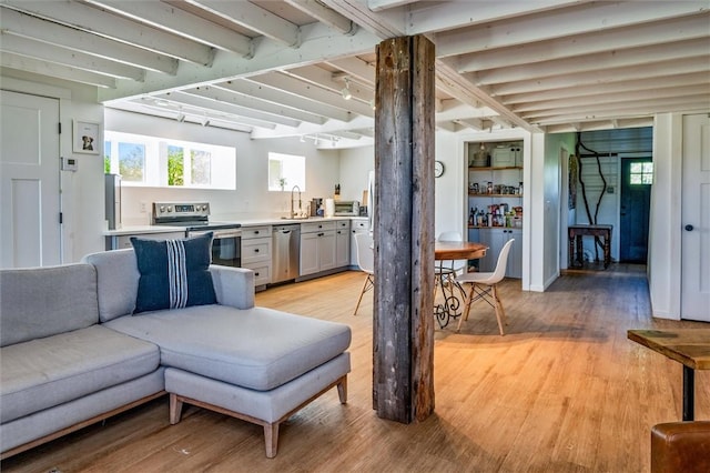 2309 Mcburney Rd, Phelps, NY 14432 - living area featuring light wood-type flooring, healthy amount of natural light, and beamed ceiling