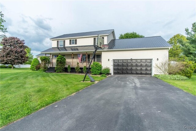 1 Carol Dr, Adams, NY 13605 - view of front facade featuring a metal roof, covered porch, an attached garage, asphalt driveway, and a front yard