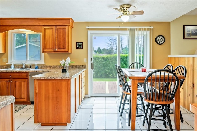 75 Red Rock Cir, Greece, NY 14626 - kitchen with a sink, brown cabinets, stainless steel dishwasher, ceiling fan, and light countertops