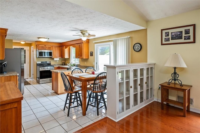75 Red Rock Cir, Greece, NY 14626 - dining room featuring ceiling fan, a textured ceiling, light wood-style flooring, and baseboards