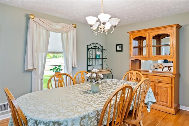 75 Red Rock Cir, Greece, NY 14626 - dining space featuring a chandelier, light wood-style floors, and a textured ceiling