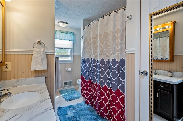 75 Red Rock Cir, Greece, NY 14626 - bathroom with a textured ceiling, a wainscoted wall, vanity, toilet, and wooden walls