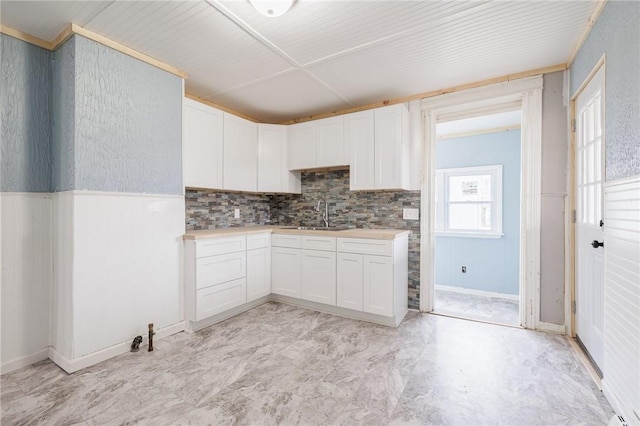 286 Kenwood Ave, Rochester, NY 14611 - kitchen featuring a sink, light countertops, decorative backsplash, and white cabinetry