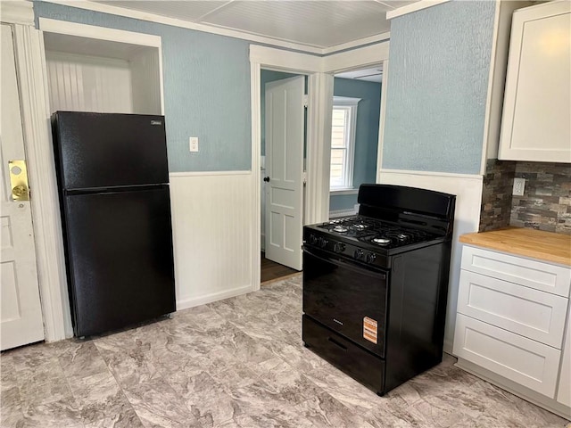 286 Kenwood Ave, Rochester, NY 14611 - kitchen with black appliances, a wainscoted wall, white cabinetry, wooden counters, and tasteful backsplash