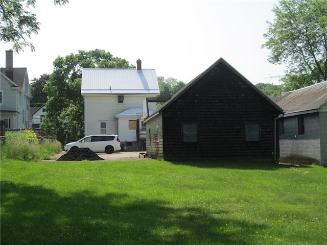 95 Wadsworth Ave, Avon, NY 14414 - rear view of property featuring a lawn, a chimney, and a metal roof