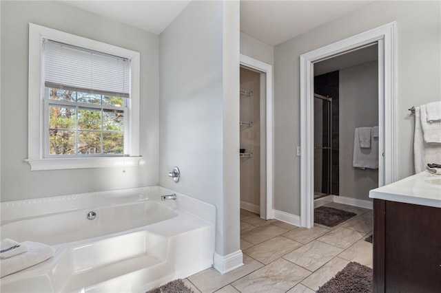 102 Trolley Line Rd, Hartwick, NY 13326 - bathroom with a bath, vanity, a stall shower, baseboards, and a walk in closet