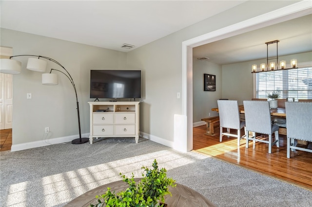102 Trolley Line Rd, Hartwick, NY 13326 - carpeted living room with a chandelier and baseboards