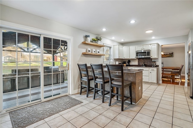 102 Trolley Line Rd, Hartwick, NY 13326 - kitchen featuring stainless steel appliances, light tile patterned floors, white cabinetry, open shelves, and a peninsula