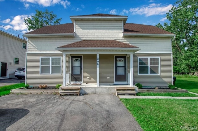 1806 Como Park Blvd, Lancaster, NY 14086 - view of front facade with roof with shingles, covered porch, and a front lawn