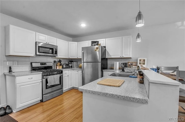 1806 Como Park Blvd, Lancaster, NY 14086 - kitchen with appliances with stainless steel finishes, a peninsula, white cabinetry, and recessed lighting