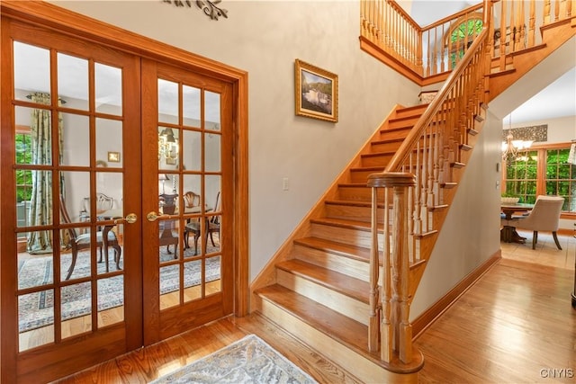 55 Redmond Rd, Trenton, NY 13304 - staircase with french doors, wood finished floors, baseboards, and a chandelier