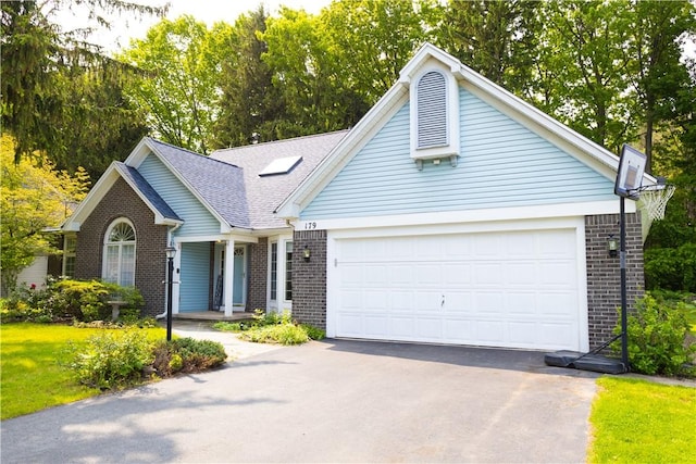 179 Kentucky Xing, Greece, NY 14612 - view of front of home with brick siding, driveway, an attached garage, a porch, and a shingled roof