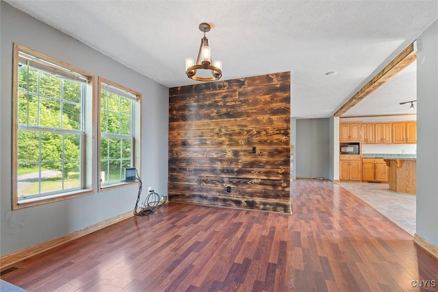 6669 Rottamore Rd, Stockbridge, NY 13409 - unfurnished dining area with light wood-style floors, a chandelier, and baseboards