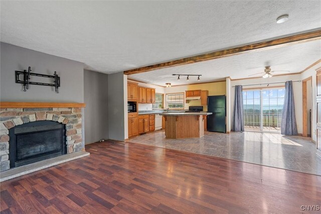 6669 Rottamore Rd, Stockbridge, NY 13409 - kitchen featuring black appliances, open floor plan, light wood-style floors, a kitchen island, and a textured ceiling