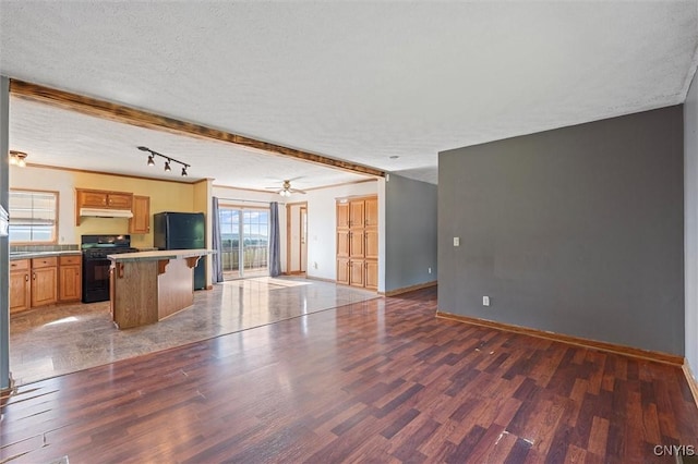 6669 Rottamore Rd, Stockbridge, NY 13409 - unfurnished living room with wood finished floors, baseboards, a textured ceiling, and a ceiling fan