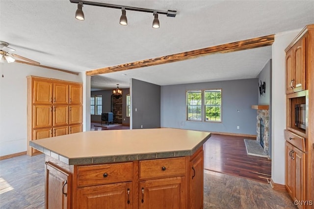 6669 Rottamore Rd, Stockbridge, NY 13409 - kitchen featuring a fireplace, baseboards, open floor plan, and ceiling fan