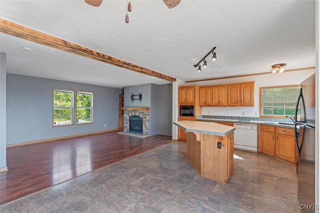 6669 Rottamore Rd, Stockbridge, NY 13409 - kitchen with dishwasher, black microwave, freestanding refrigerator, open floor plan, and light countertops
