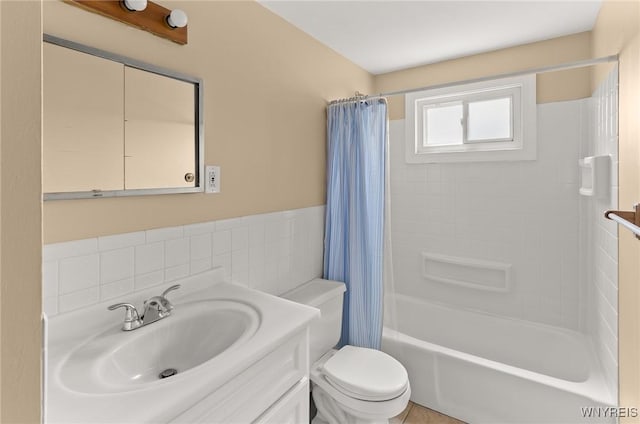 51 N Seine Dr Unit 1 & 2, Cheektowaga, NY 14227 - bathroom featuring vanity, toilet, shower / bath combo with shower curtain, tile walls, and a wainscoted wall