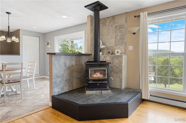 3477 Mcclary Rd, Lafayette, NY 13084 - detailed view of a wood stove, wood finished floors, a chandelier, baseboards, and recessed lighting